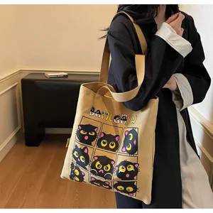 Vue détaillée du sac cabas en toile avec motif de chat noir mignon, anses solides et grand espace.