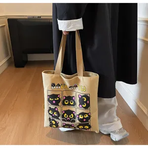 Détail du sac cabas en toile affichant un joli motif de chat noir et des poignées solides.