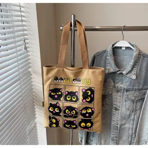 Vue détaillée d'un sac cabas en toile beige avec imprimé chat noir drôle pour un usage quotidien.