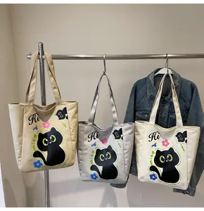 Vue détaillée de sacs cabas en toile mignons avec imprimé chat noir sur un portant.