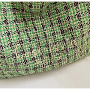 Close-up detail of the green houndstooth woolen bag with fine embroidery texture.
