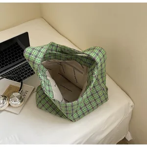 Green wool plaid hobo bag detail, cozy lifestyle setting with laptop and headphones interior.