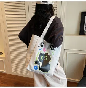 Vue détaillée du sac cabas en toile décontracté avec un joli imprimé de chat noir.