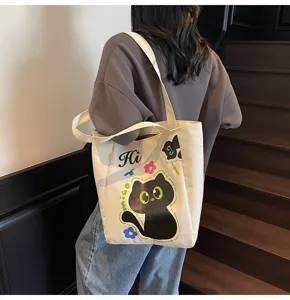 Détail de sac bandoulière en toile style japonais, avec illustration de chat noir.