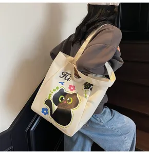Vue détaillée du sac en toile mignon chat noir avec imprimé floral et style de port.