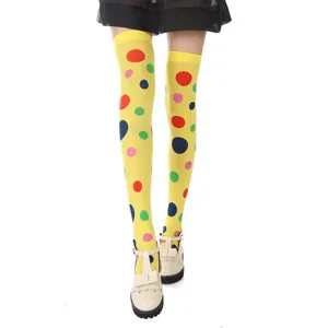 Détail de motif à pois colorés sur chaussettes montantes jaunes vives pour fête.