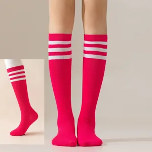Pink knee high tube socks detail featuring classic white three stripes for stylish party wear.