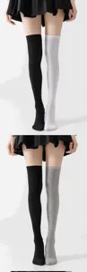 Primer plano detallado de calcetines altos color-block en negro, blanco y gris.