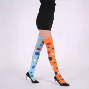 Gros plan de bas colorés à pois au-dessus du genou avec des couleurs contrastées vibrantes.
