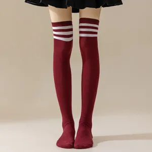 Close-up detail of burgundy over-the-knee socks with white three stripes, preppy JK style.