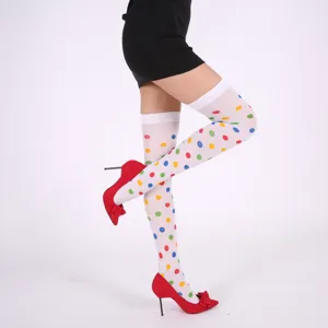 Détail en gros plan de bas montants à pois colorés assortis à des talons hauts rouges.