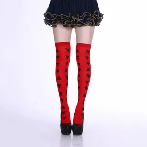 Detail view of red over-the-knee socks featuring classic black poker suit print patterns.