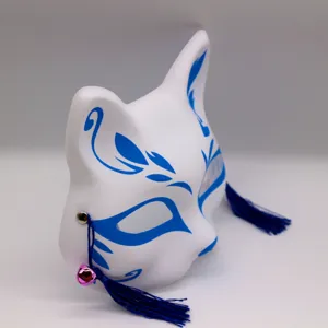 Vue détaillée d'un masque de renard kitsune blanc en PVC avec des glands bleus et une cloche rose.