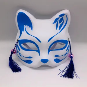 Vue de detail en gros plan d un masque de renard japonais blanc avec des motifs et des pompons.