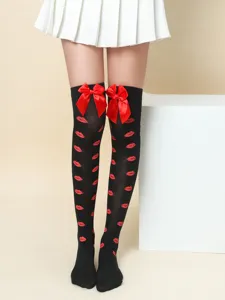Detailed view of black thigh high over the knee socks with red lips print and satin bow.