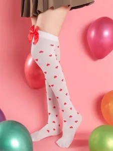 Close-up detail of white over-the-knee stockings with red heart prints and cute bow.