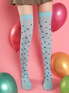 Heart print over-the-knee socks detail view, blue stockings with cute heart patterns for date.