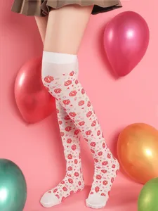 Close-up detail of white over-the-knee stockings featuring red lips and heart print for party.