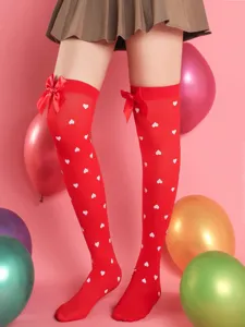 Red over-the-knee socks with white heart print and cute bow detail, perfect for date outfits.