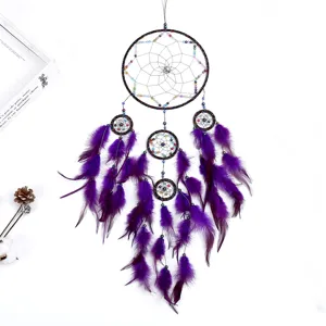 Detailed view of the large purple dream catcher with feathers and colorful beads hanging.