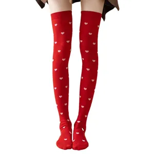 Detailed view of red over-the-knee socks featuring sweet little heart patterns for wear.