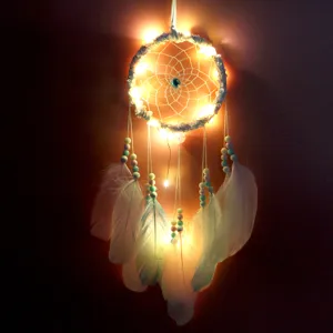 Attrape-rêves rose fait main avec des lumières LED et des plumes pour décoration murale