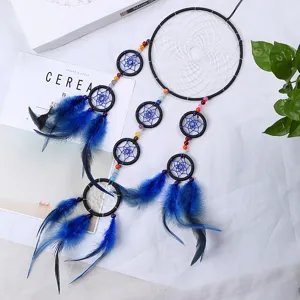 Handmade blue dream catcher detail shot with feathers and beads for wall home decor item.