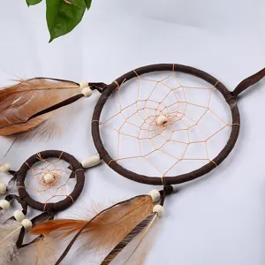 Detailed view of a handmade brown double ring dream catcher with feathers and wooden beads.