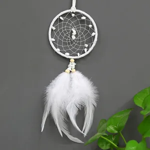 Vue détaillée du capteur de rêves blanc fait main avec pierres naturelles et plumes douces.