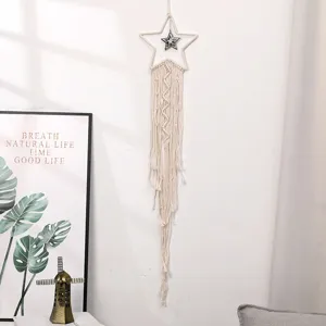 Dettaglio appendiabiti da parete stella in macramè fatto a mano, decoro in corda di cotone.