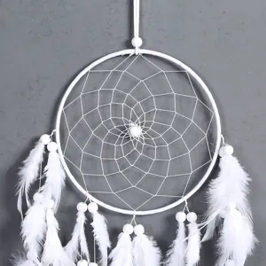 White feather dreamcatcher detail shot, bohemian style wall hanging home decor accessory.
