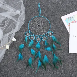 Detailed view of blue dream catcher with feathers hanging on textured background decor.
