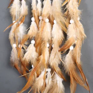 Detailed view of bohemian dreamcatcher hanging decor with brown feathers and white beads.