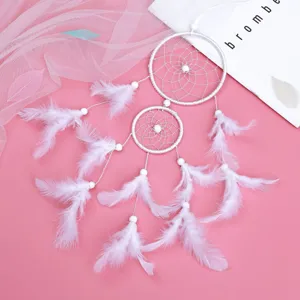White double ring dreamcatcher wall hanging with soft feathers and beads for bedroom decor.