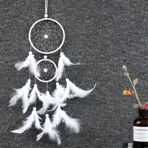 Detail view of white double ring dream catcher hanging ornament with feathers and beads.