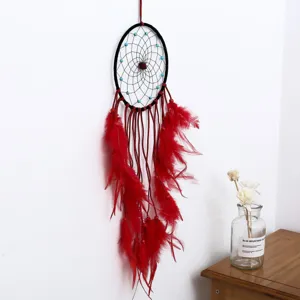Handmade red dream catcher wall hanging decor with feathers for bedroom home interior design.