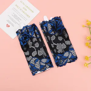 Vista detallada de guantes de encaje negro y azul sin dedos, con delicado patrón floral.