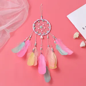 Detalle en primer plano de atrapasueños pastel hecho a mano con plumas para decoración.