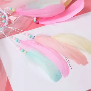 Detalle de pluma de atrapasueños hecho a mano con cuentas pastel rosa, amarilla y menta.