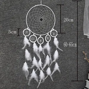 White handmade dream catcher with feathers, hanging wall decor for bedroom or home interior.