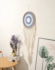Grote handgemaakte macramé dromenvanger wanddecoratie met veren en blauw wit geweven webontwerp.