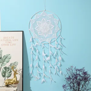 Handmade white crochet dream catcher wall hanging detail featuring feather tassels.
