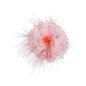 Detailed close up of pink fabric flower with soft feathers and sparkling hanging beads.