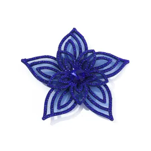 Close-up detail of the deep blue rhinestone mesh flower applique, showing sparkling crystal layers.