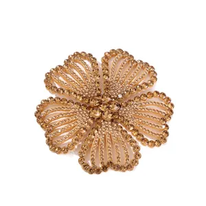 Close-up detail of sparkling champagne rhinestone flower shoe clip and garment accessory part.