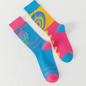 Gedetailleerd uitzicht van kleurrijke asymmetrische katoenen sokken met regenboog jacquardpatroon.