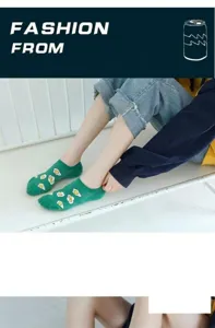 Nahaufnahme von grünen Sneakersocken mit süßem Spiegelei-Muster auf weißer Sitzbank.