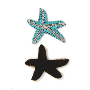Strass zeester patch detail, fonkelende blauwe kristallen en zwarte achterkant.
