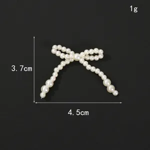 Close-up detail of the pearl bow DIY accessory, showing its size and shape very clearly.