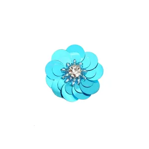 Primer plano detallado de parche de flor de lentejuelas azules con cristal, accesorio hecho a mano.